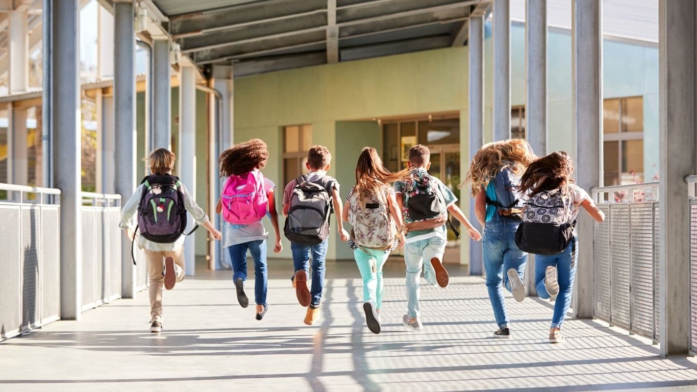 Jugendliche laufen in Richtung Schulgebäude